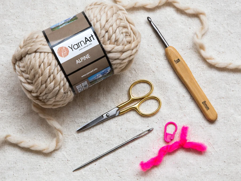 YarnArt Alpine oatmeal yarn 8mm hook scissors tapestry needle pink stitch marker flat lay