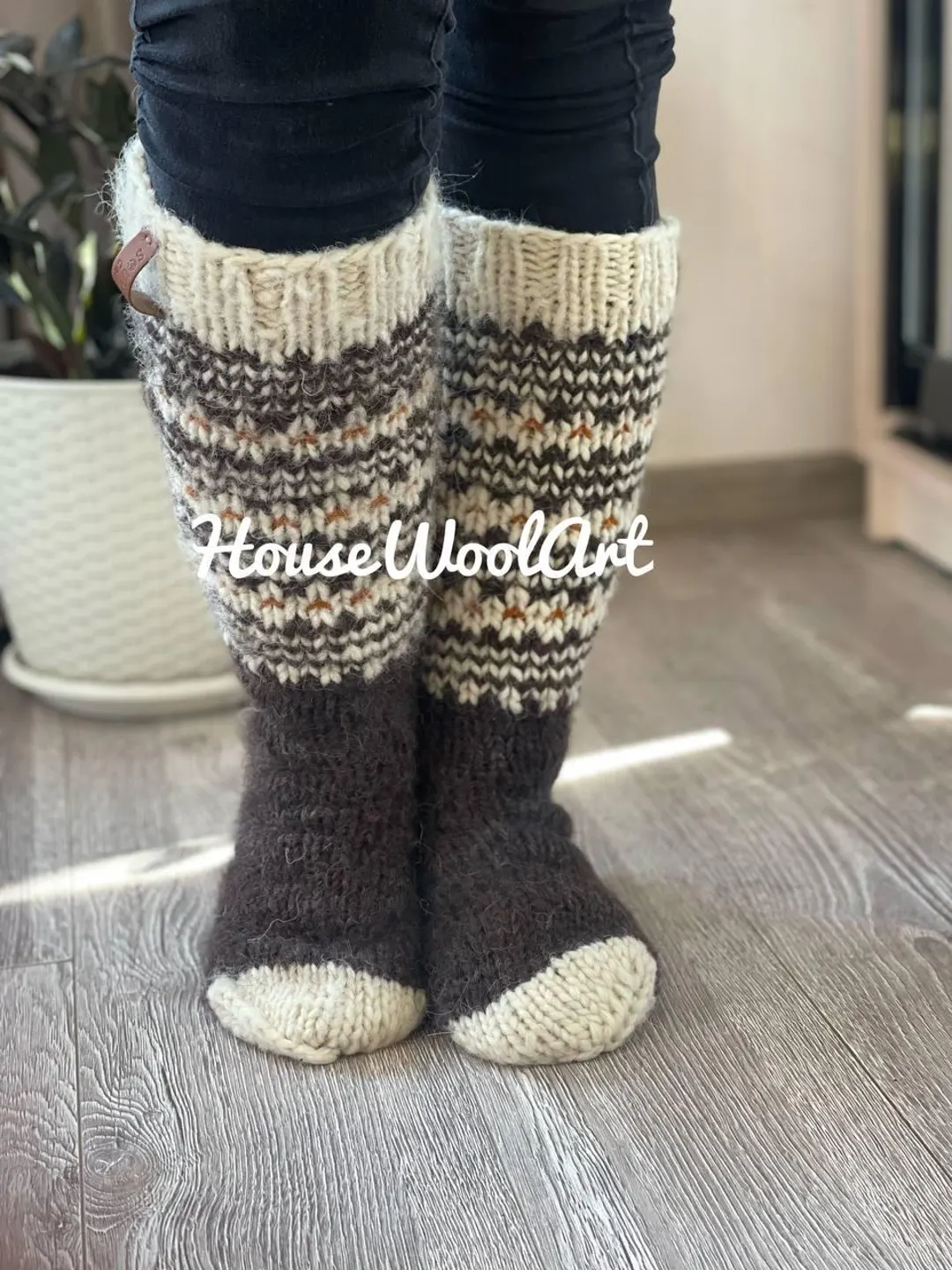 Handmade tall wool house boots with cream cuff and Nordic pattern — thick knitted slipper socks on wooden floor