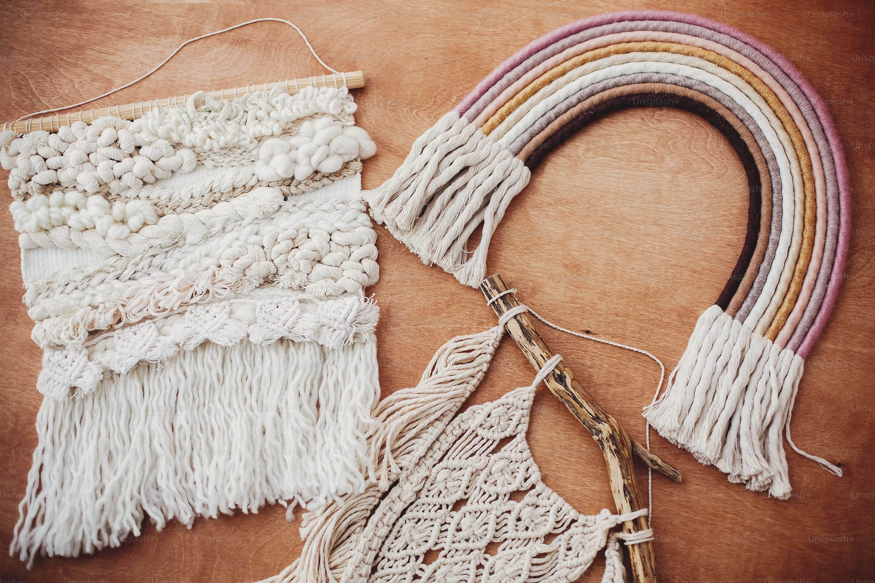 Stylish macrame and rainbow decoration on wooden table. Modern boho wall hanging and rope rainbow for baby room or simple stylish girl room. Wall macrame decor photo
