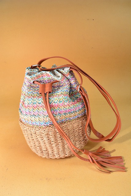 Pastel striped crochet bucket bag with leather tassel straps on yellow background — handmade boho purse with woven texture