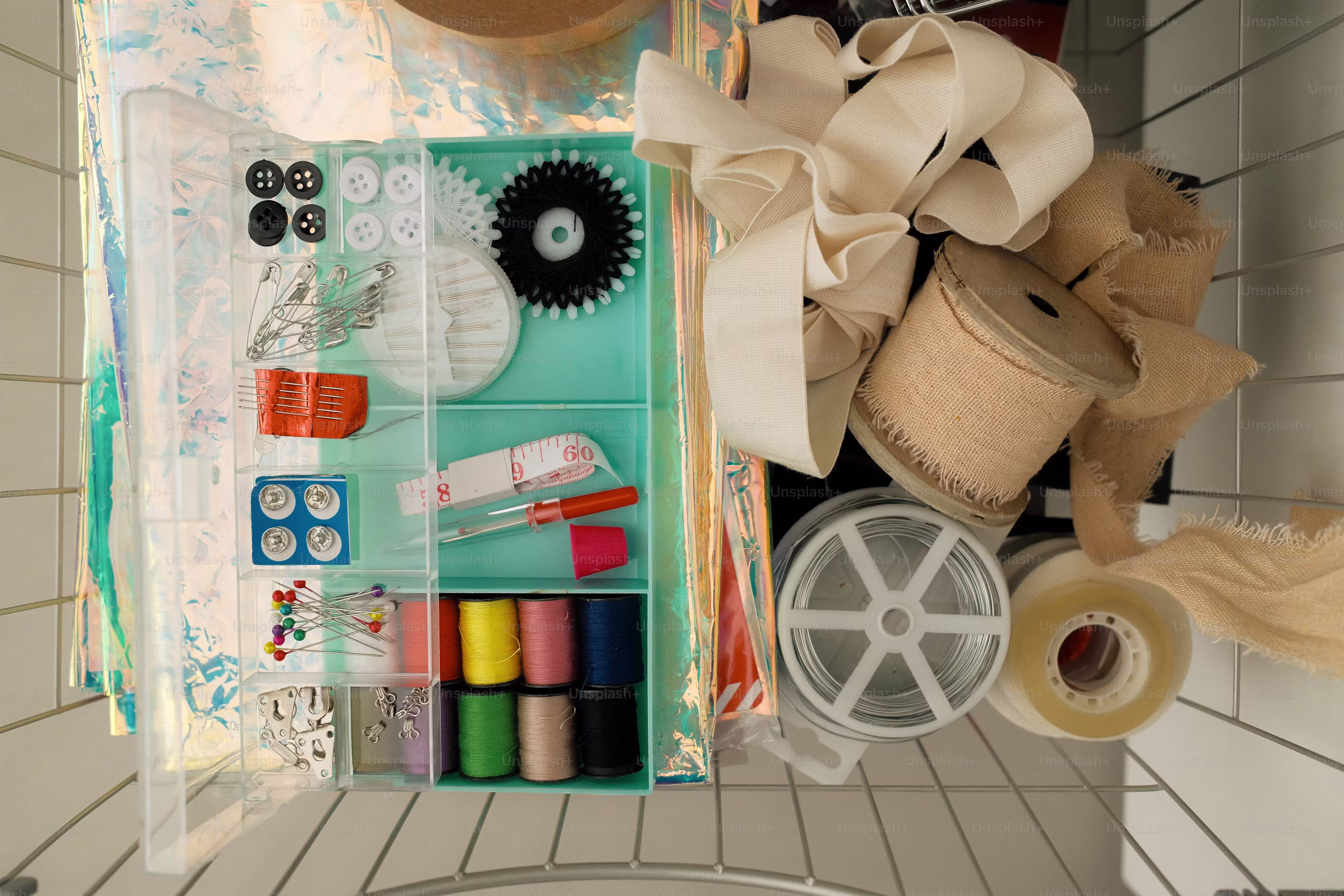 Sewing kit supplies, including spools of thread and fabric. photo – Blue Image on Unsplash